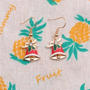 Christmas bell earrings set with red and green enamel and rhinestones on fabric background