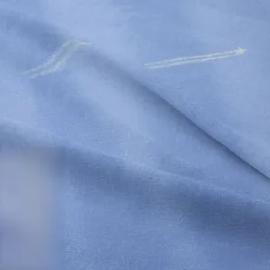 Macro shot of light blue knitted tapestry fabric with white star and wave patterns