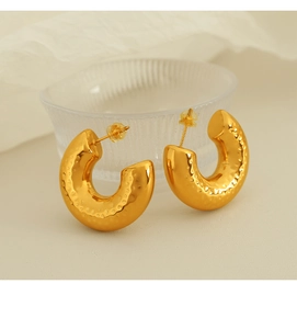 Detailansicht goldener C-Ohrringe mit gehämmerter Textur und sicherem Steckverschluss
