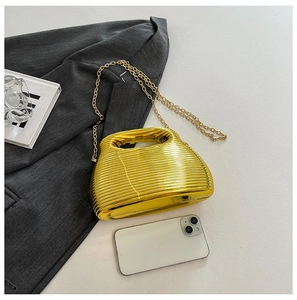 Close-up of golden ripple texture handbag with elegant metal chain and glossy finish