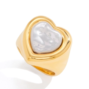 Macro detail of wide golden band featuring a glossy baroque heart pearl inlay