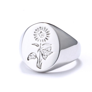 Macro detail of silver sunflower signet ring with engraved floral pattern on smooth finish