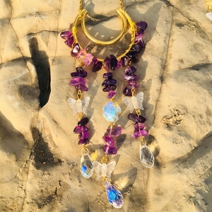 Detailed shot of golden wire crescent moon with purple crystals and butterfly suncatcher