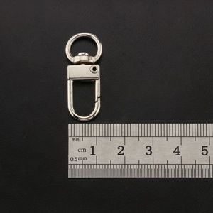 Macro detail of silver swivel lobster clasp measuring 3.5cm on black leather background