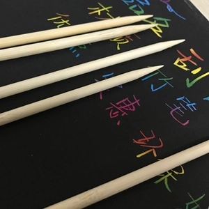 Bamboo scratch art pens for kids featuring sharp tips for creative drawing on black paper