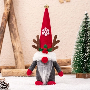 Christmas gnome doll with red hat and reindeer antlers on a snowy festive background