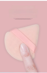 Vista dettagliata di un piumino trucco triangolare rosa con consistenza elastica