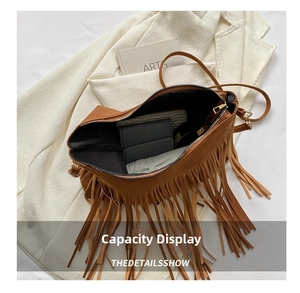Interior view of brown tassel shoulder bag showing large capacity with a wallet