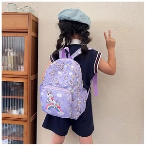 Rear view of a child wearing a purple unicorn backpack with rainbow and star prints