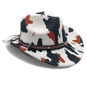 Detail of western cowboy hat with cow print pattern and leather band with bullhead charm
