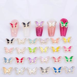 Macro view of colorful 3D butterfly nail charms with gold borders and rhinestones