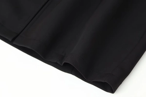 Detailed close-up showing precision double-row stitching and fabric texture on a black dress