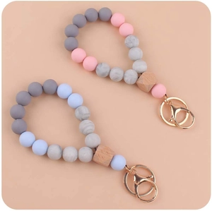 Detailed view of silicone beaded wristlet keychain with wooden bead and gold lobster clasp