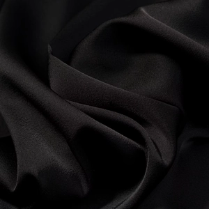 Gros plan sur un tissu en soie noire à la texture lisse et au fini brillant élégant
