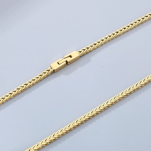 Polished gold woven Chopin chain necklace with a square clasp on a light blue background