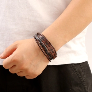 Men's vintage brown multilayer braided leather bracelet with cross emblem on model