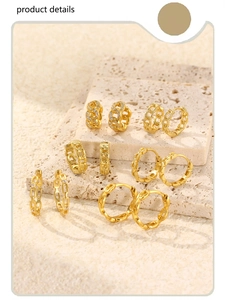 Macro view of gold chain link geometric earrings with sparkling zircon on stone stand