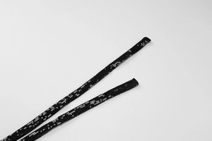 Gros plan sur les bretelles à paillettes noires d'une robe sexy à dos nu réfléchissant