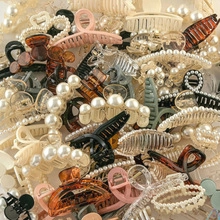 Detailed top view of various colorful acrylic hair claw clips in matte and pearl finishes