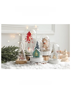 Détail d'une cloche de Noël en verre avec renne et lumières LED sur neige artificielle