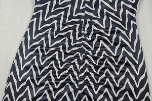 Détail du motif géométrique bleu ondulé et de la texture froncée sur la robe