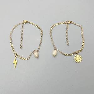 Close-up of 18K gold-plated bracelets featuring daisy charms and elegant pearl details