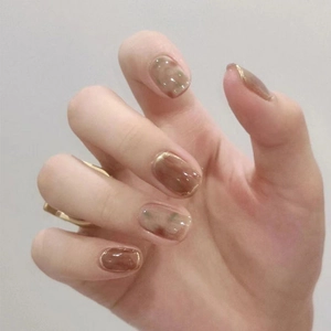 Handmade amber marble press-on nails with luxury gold edges and glossy finish