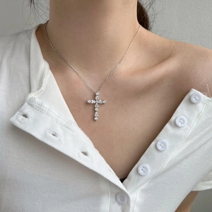 Detail of S925 sterling silver cross necklace with pearl and opal stone on female neck