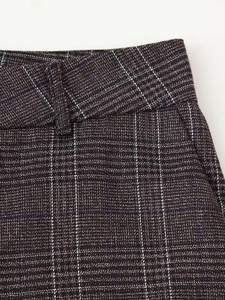 Détail du tissu à carreaux marron foncé avec texture rétro et passants de ceinture