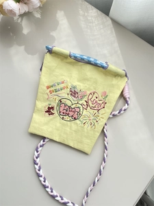 Détails de broderie sur sac en tissu oxford jaune avec bandoulière tressée colorée