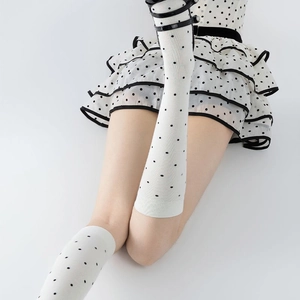 Retro JK style knee-high white socks with black polka dots and knitted cotton texture