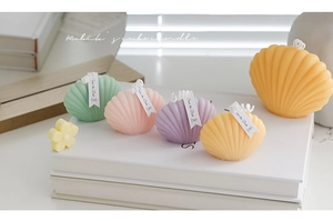 Macro detail of colorful shell-shaped scented candles in mint green and pastel pink