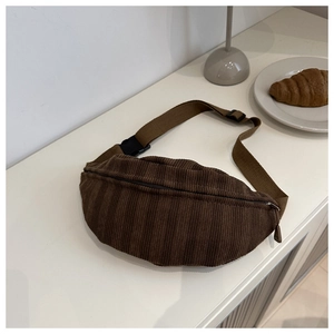 Close-up of brown corduroy waist bag showing soft texture and adjustable strap