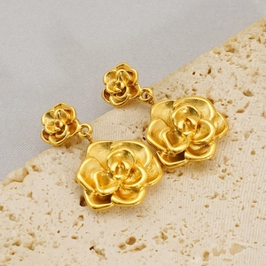 Dettaglio macro di orecchini a rosa in oro 18K con strati strutturati su pietra
