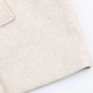 Close-up of beige wool blend fabric texture with fine stitching details on the coat