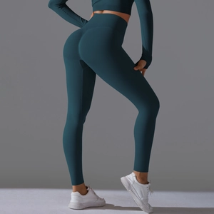Detail of high-waist dark teal seamless yoga set showing scrunch butt and thumb hole sleeves