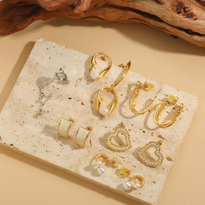 Detailed set of gold and pearl earrings including heart studs and geometric drop designs