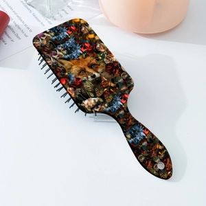 Close-up of portable hairbrush featuring a forest fox head and floral art print pattern