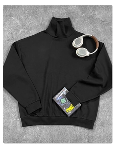 Piatto di t-shirt nera a collo alto con libro retrò e cuffie su texture di cemento moderna