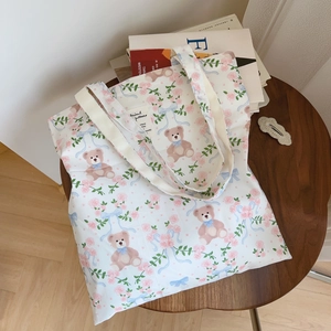 Détail de l'imprimé floral et de l'étiquette sur le sac fourre-tout en toile blanche
