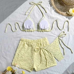 Dettaglio ravvicinato del set bikini tre pezzi giallo chiaro con tessuto jacquard a rilievo