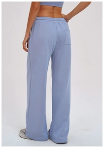 Rear view detail of loose light blue sweatpants with elastic waist and back pocket