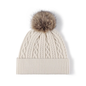 Cream knit cable beanie with a faux fur pompom for winter warmth and fashion