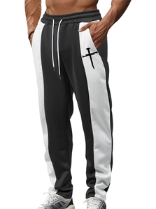 Detail of men's casual joggers showing black and white contrast panels and cross print