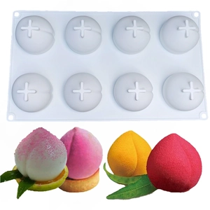 Macro shot of peach shaped silicone mousse molds and colorful finished cakes
