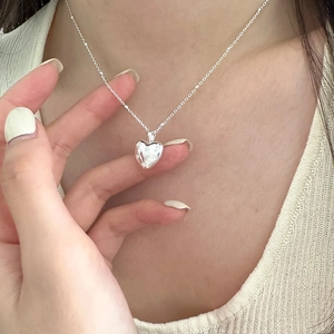 Close-up of S925 sterling silver heart pendant necklace on model with vintage texture