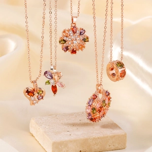 Elegant rose gold necklaces with colorful zircon heart and flower pendants on silk fabric