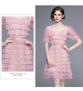 Gros plan sur la texture de la dentelle et le design de la robe rose à volants