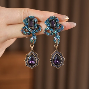 Détails des boucles d'oreilles serpent vintage avec gouttes en cristal violet et strass