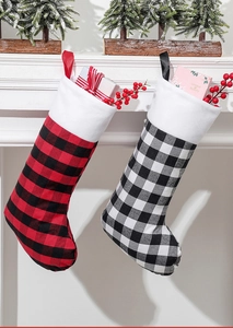 Chaussettes de Noël classiques à carreaux rouges et blancs suspendues à la cheminée décorée